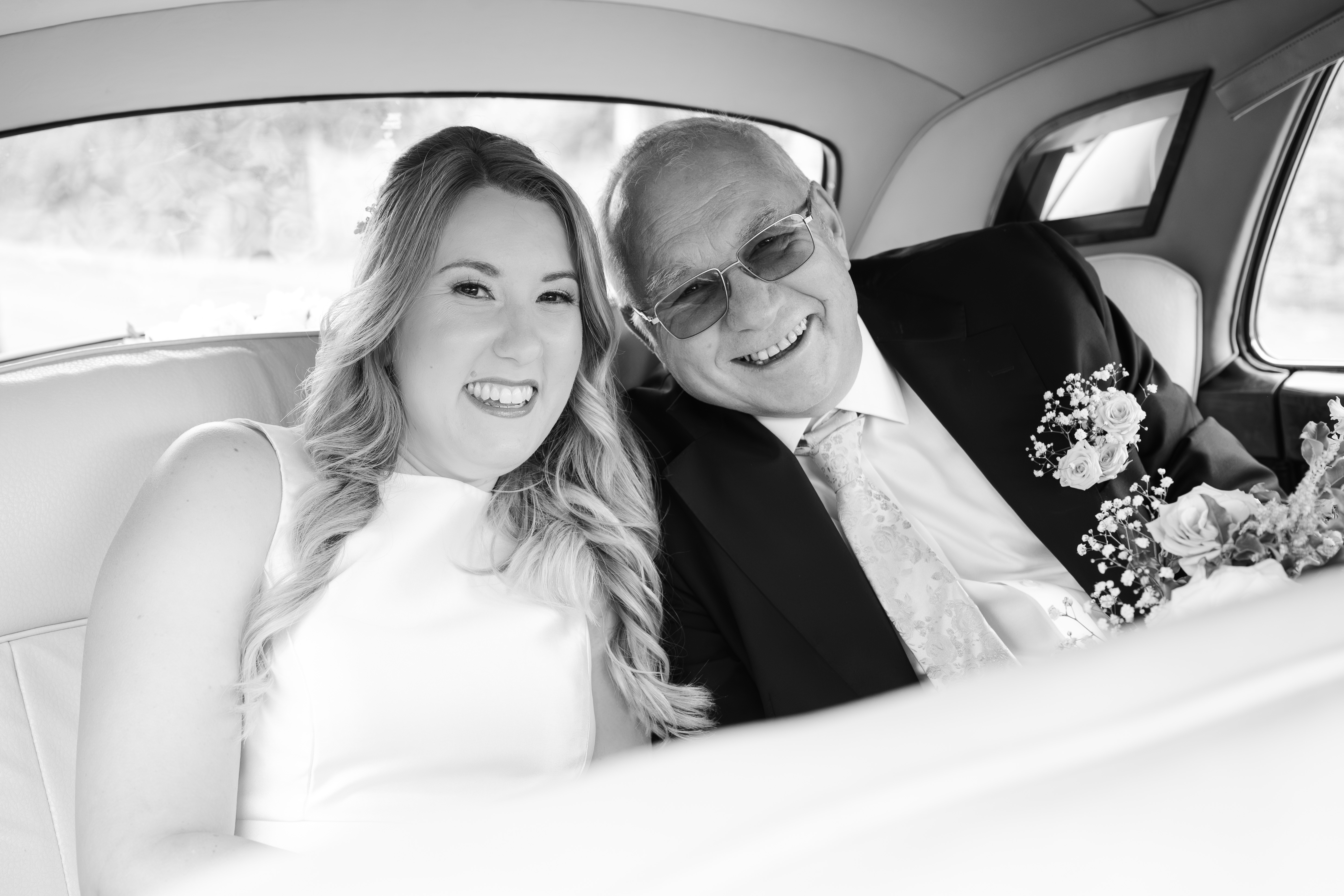 A bride and her father in a vintage car on her wedding day